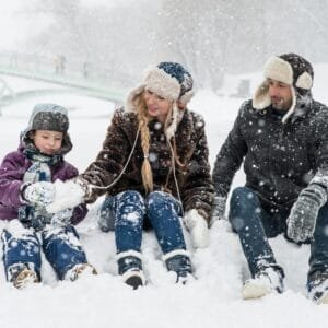 Woman, Man and Girl Sitting on Snow